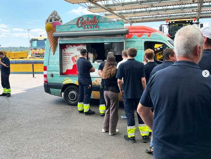 Viele Menschen warten in einer Schlange vor einem Eiswagen