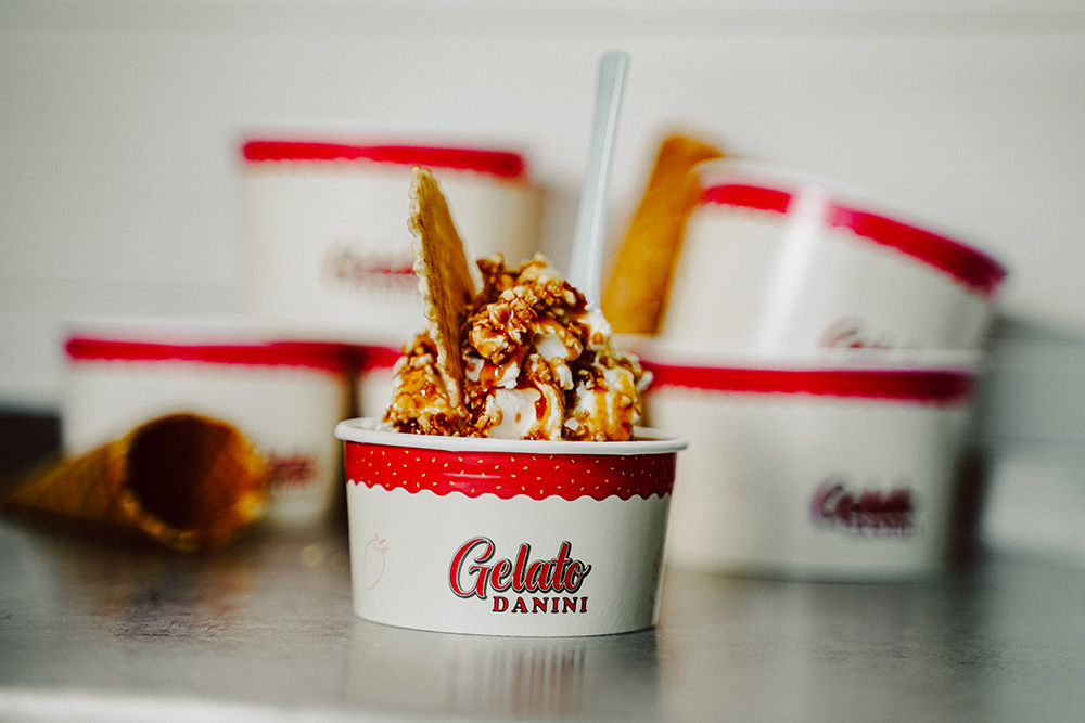 Eisbecher mit der Aufschrift Gelato Danini mit Karamell Soße und Waffel